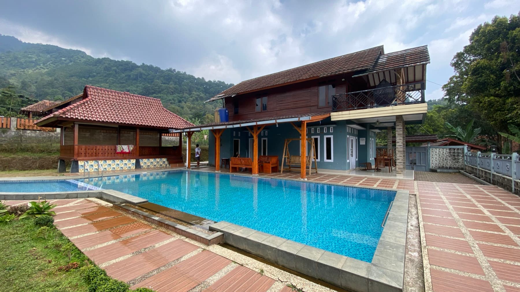 Kolam renang dan bangunan Villa Yudha dengan Gunung Burangrang di belakangnya